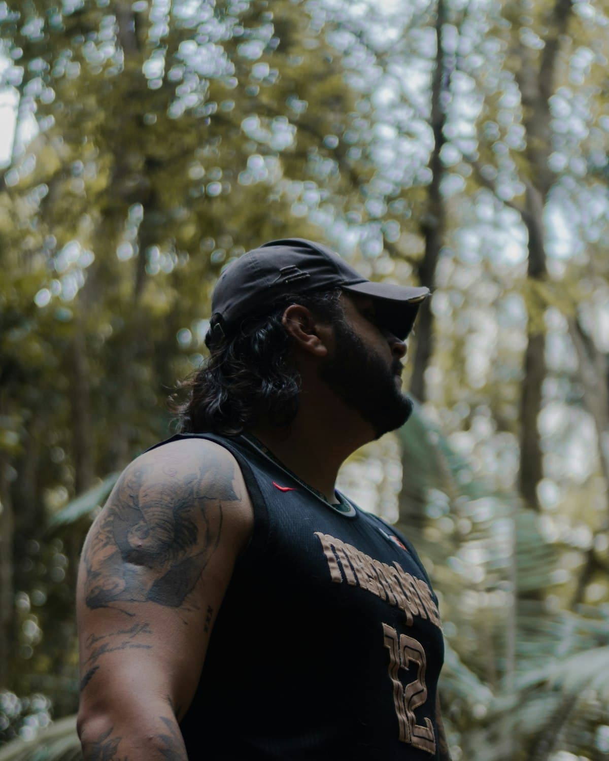 Person in a black trucker cap in dense forest