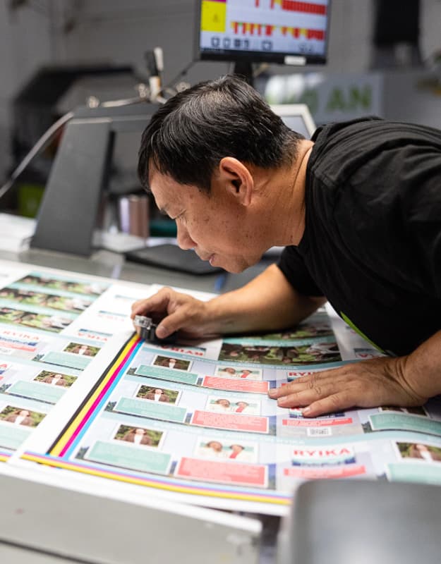 Print NW press operator inspecting a CMYK proof